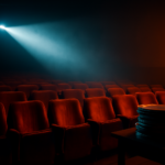 Suasana bioskop remang dengan berkas proyektor dan gulungan film